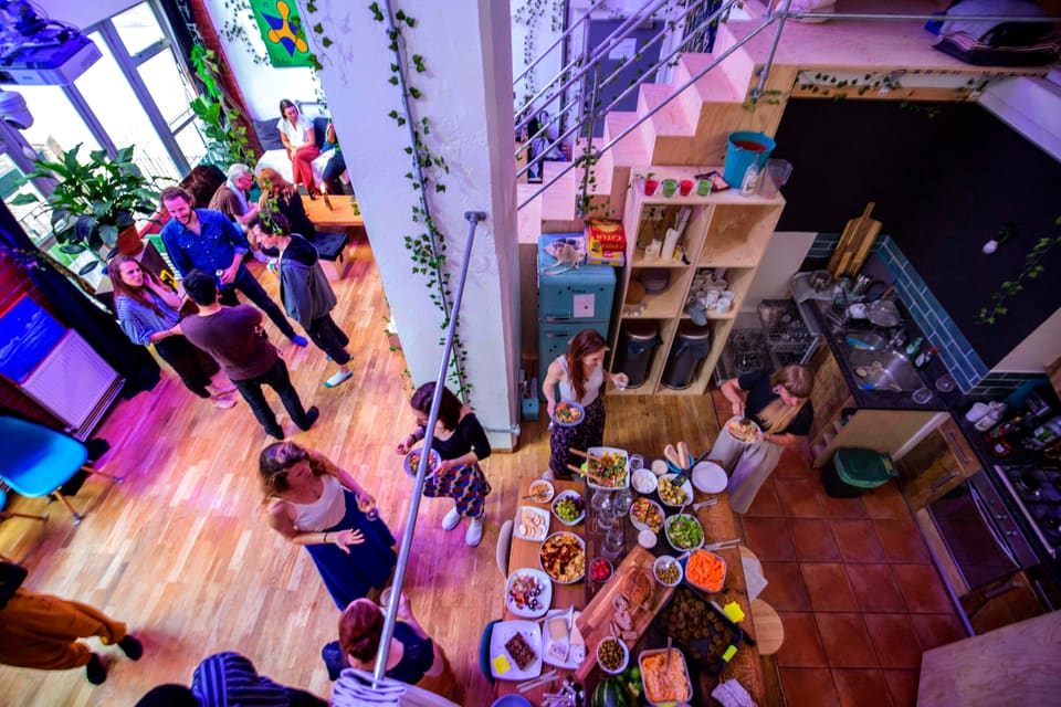 Overhead view of a party gathered around a shared table of food