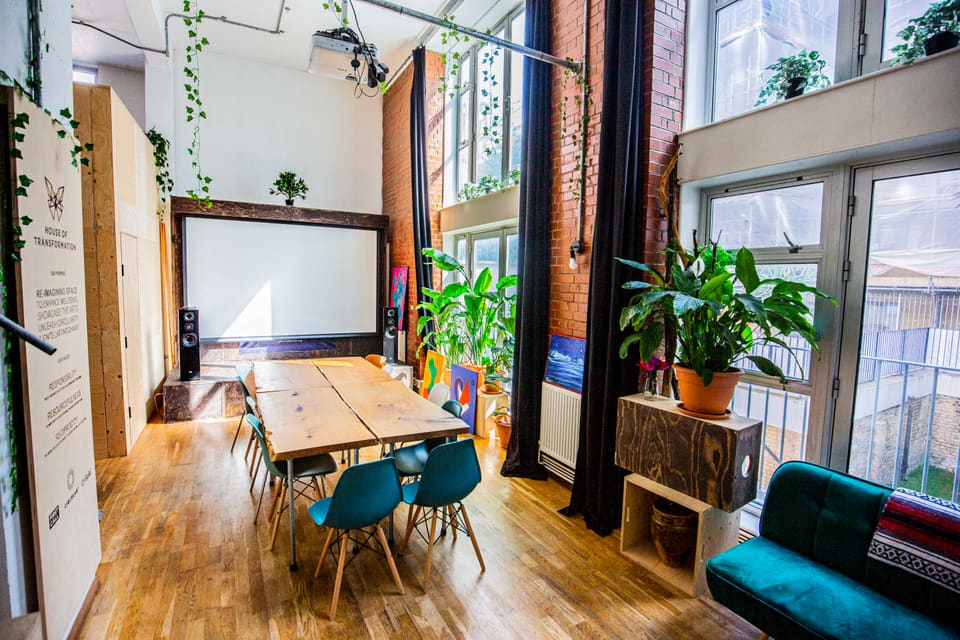 Meeting table and teal chairs facing the projector screen
