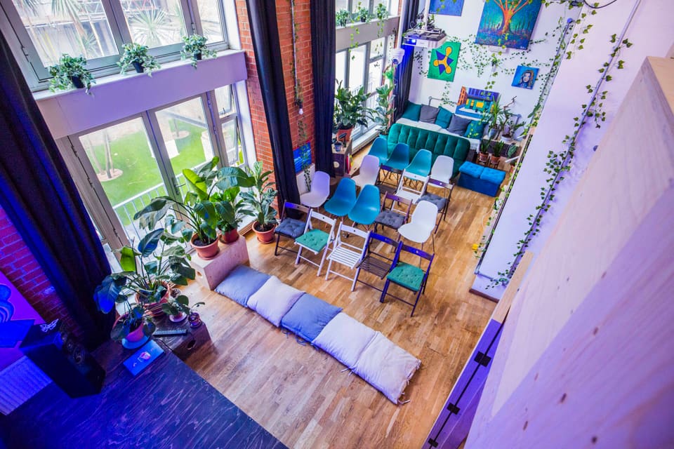 Floor cushions and armchairs arranged for a talk below the mezzanine