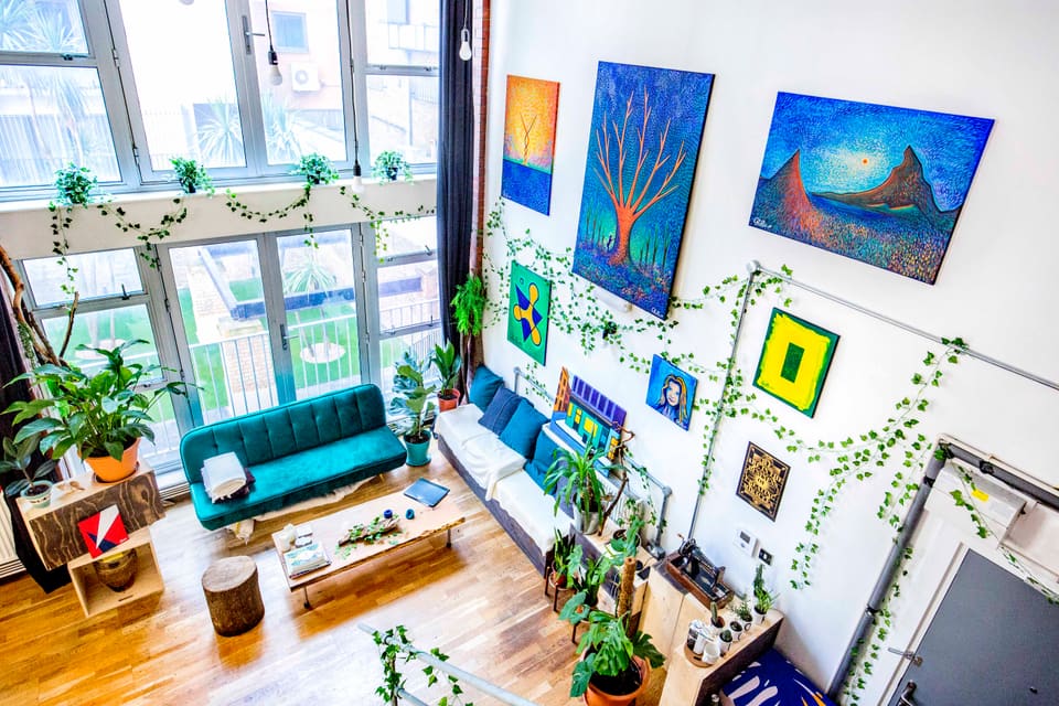 Artwork hung across the white wall above the teal sofa