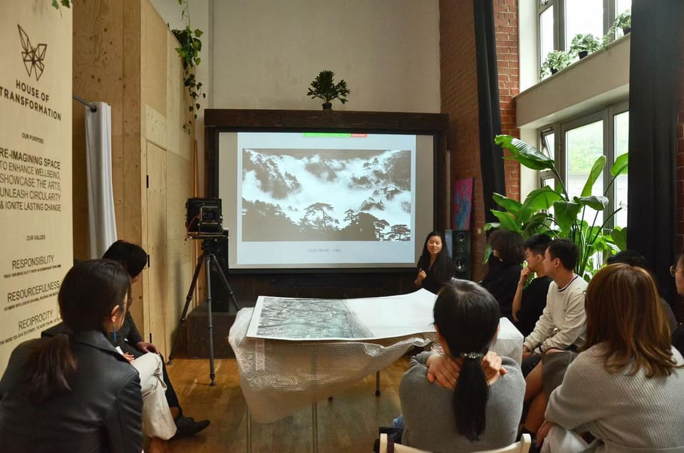 An audience watching a film screening in the back meeting room
