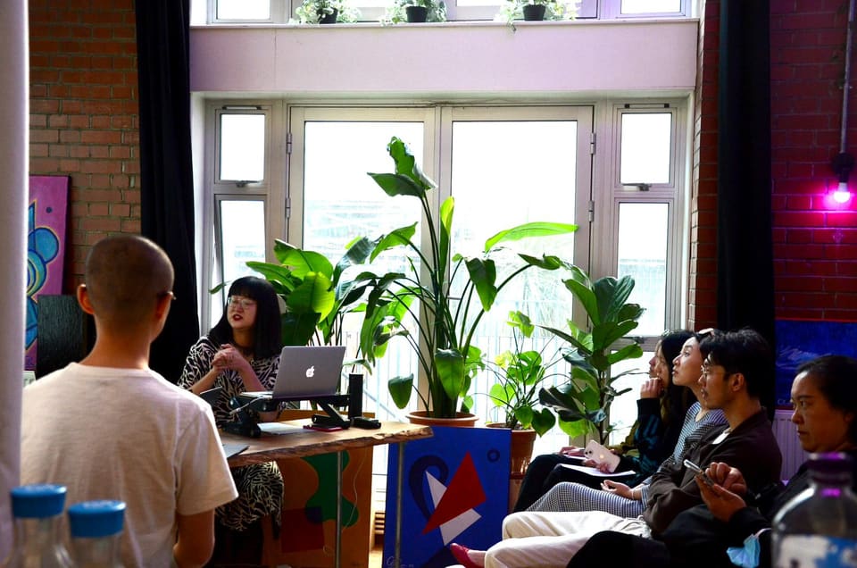 People working at desks among the plants in the daylit workspace