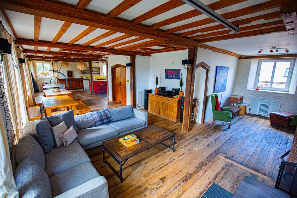 The lounge at Selgars Mill, sofas and board games under oak beams