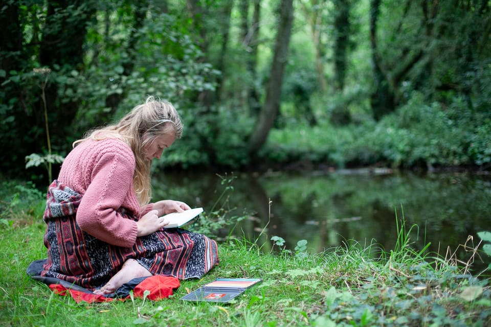 A guest reading beside the River Culm at Selgars Mill